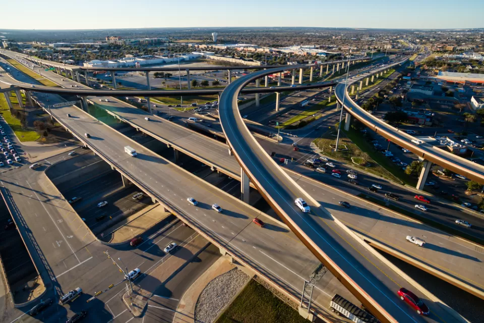 Aerial Texas Hill Country at sunset, with an aerial view of a highway interchange and Interstate 35 in Austin, Texas.